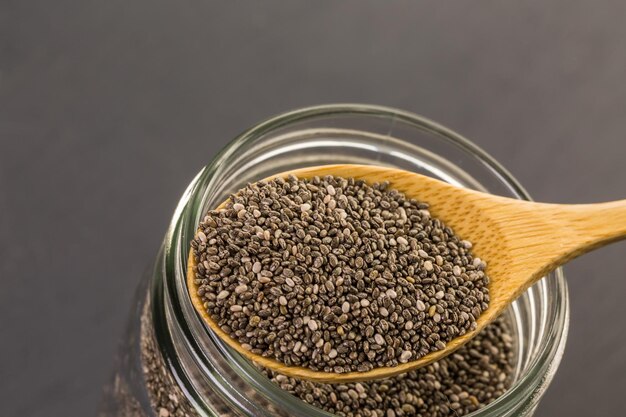 Healthy Chia seeds in a wooden spoon on the table close-up.