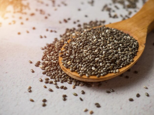 Healthy chia seeds in a wooden spoon on the table closeup