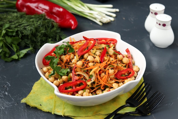 Healthy chickpea, Korean carrot, sweet pepper and onion salad decorated with black sesame