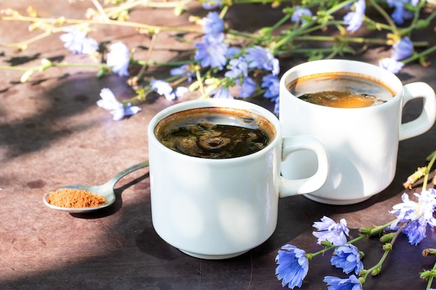 컵에 담긴 건강한 치커리 음료는 치커리 꽃으로 장식되어 있습니다. 허브 음료, 커피 대용품입니다.