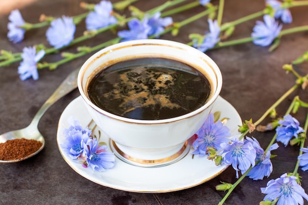 Healthy chicory drink in cup decorated chicory flowersHerbal beverage coffee substitute Selective focus