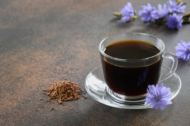 ガラスカップで飾られたキクニガナの花の健康的なキクニガナの飲み物。