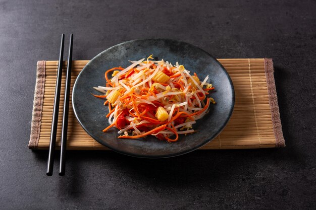 Healthy Chinese cabbage salad in plate on black background