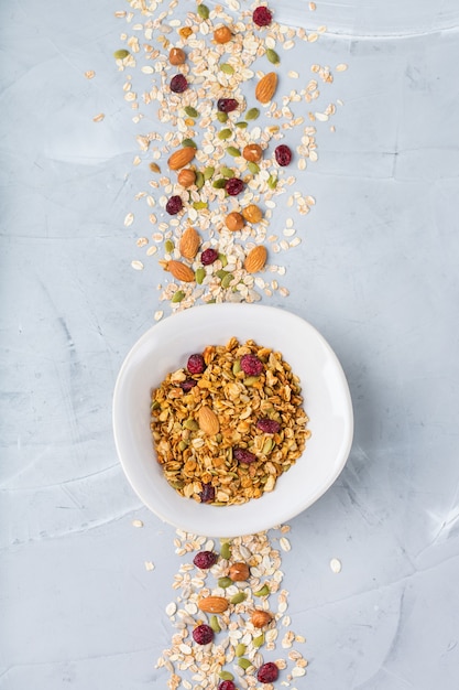 Healthy clean eating, dieting and nutrition, fitness, balanced food, breakfast concept. Homemade granola muesli with ingredients on a table. Top view flat lay copy space background