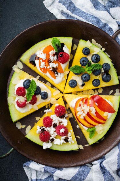 Healthy clean eating dieting and nutrition seasonal summer concept Watermelon pizza with berries fruits yogurt feta cheese on a table Top view flat lay background