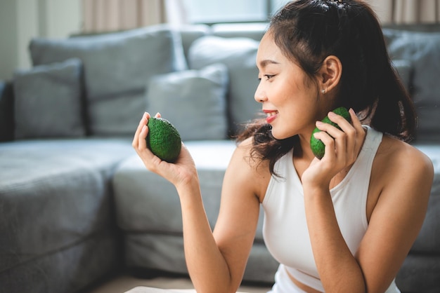 健康的なきれいな食品のコンセプト、ダイエットライフスタイルのための新鮮な野菜を持つアジアの女性、家で有機的な食事を食べる幸せな菜食主義の女性の女の子