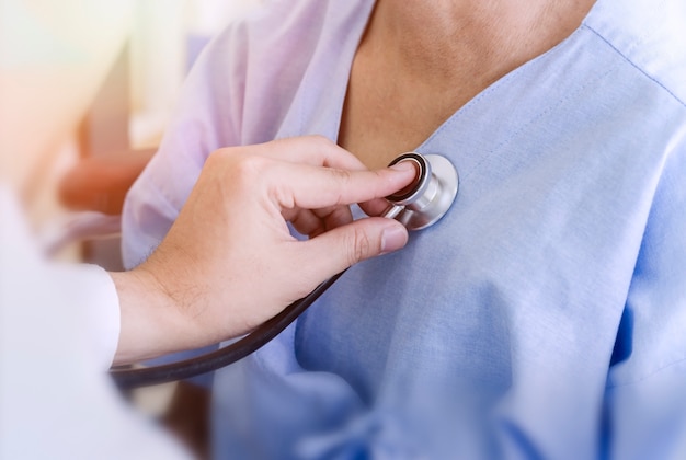 Healthy concept; Doctor checking patient's heart with stethoscope at a hospital