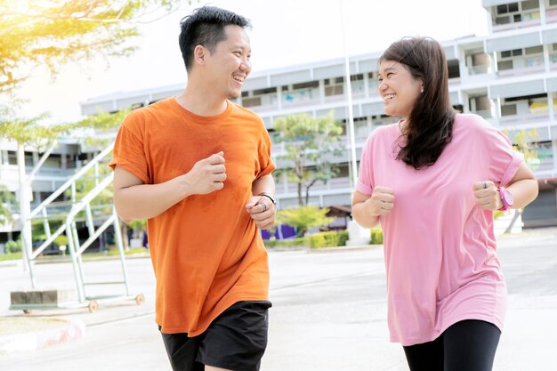 Concetto sano uomini e donne che fanno jogging insieme felicemente è un esercizio al mattino con tempo luminoso