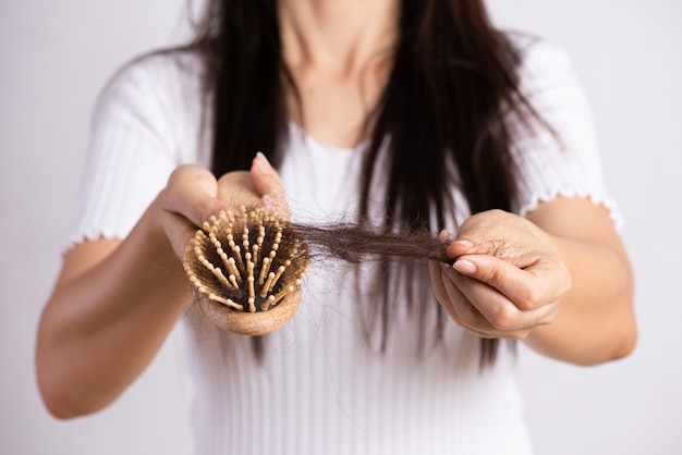 Здоровая концепция. Женщина показывает свою кисть с поврежденной длинной потерей волос