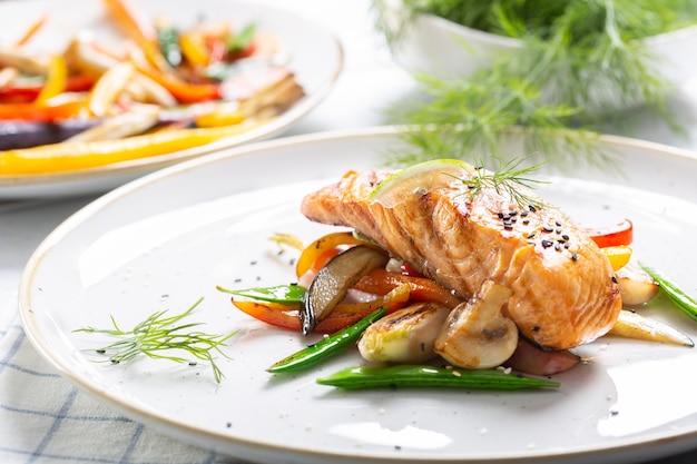 Healthy cooked Norwegian salmon served with grilled vegetables and mushrooms.