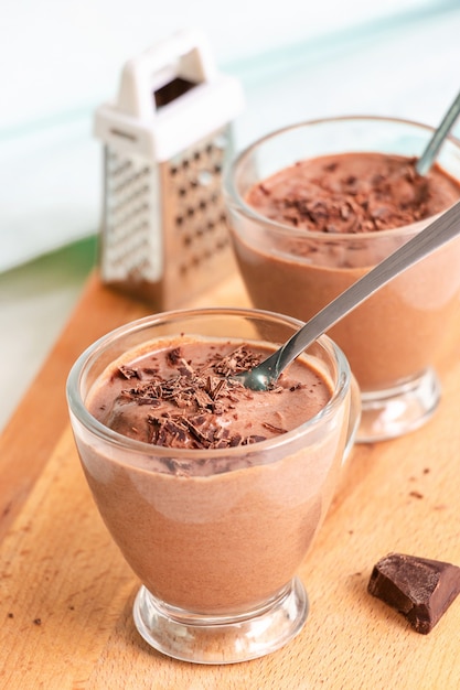 Healthy dessert chocolate pudding serving cups wooden cutting boarding Selective focus