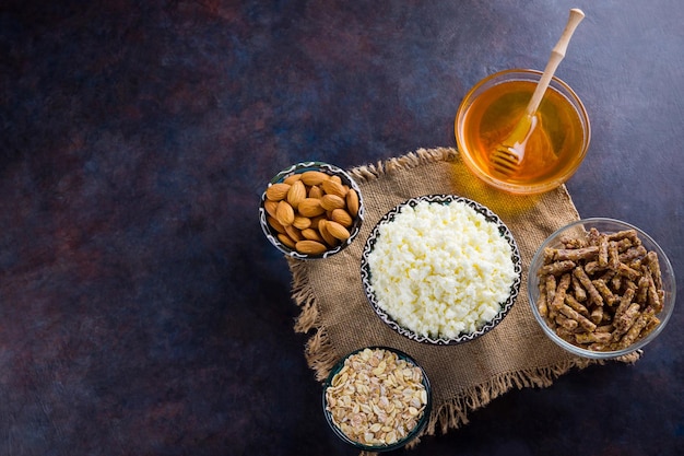 Foto colazione a dieta sana su burlap ingredienti per una colazione sana farina d'avena granola miele