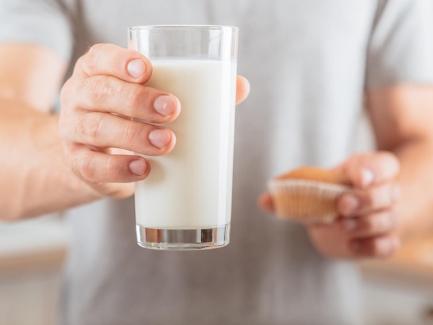 Healthy diet Energetic nutrition Closeup of glass of soy milk and muffin in man hands