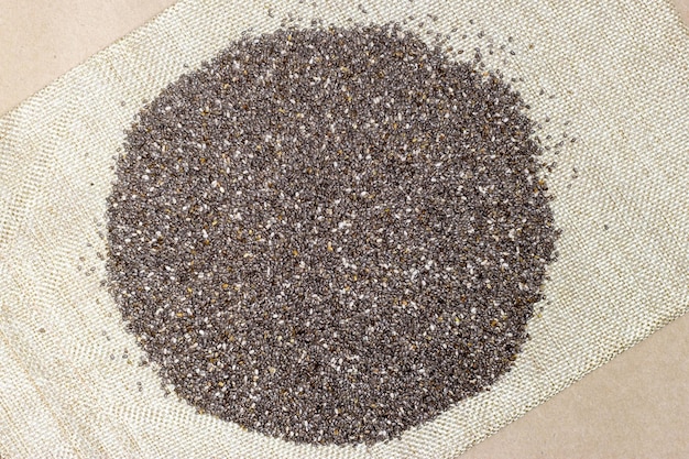 Photo healthy and diet food chia seeds or superfood in linen cloth over cardboard texture background