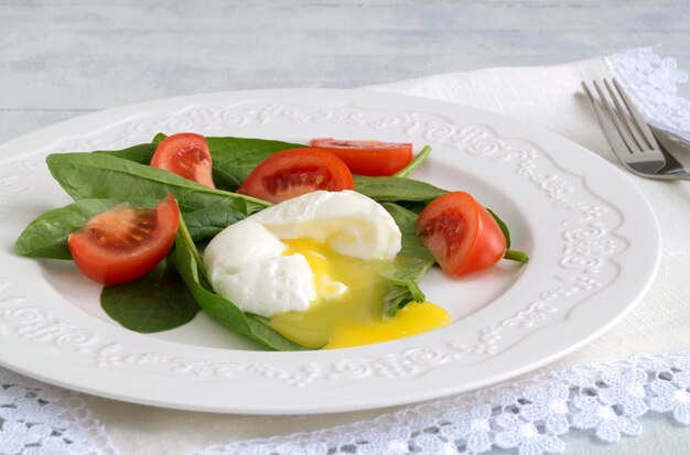 Healthy diet. Medium boiled egg with fresh spinach.