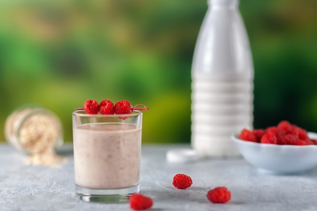 Healthy dietary food oatmeal milkshake with bananas and raspberries