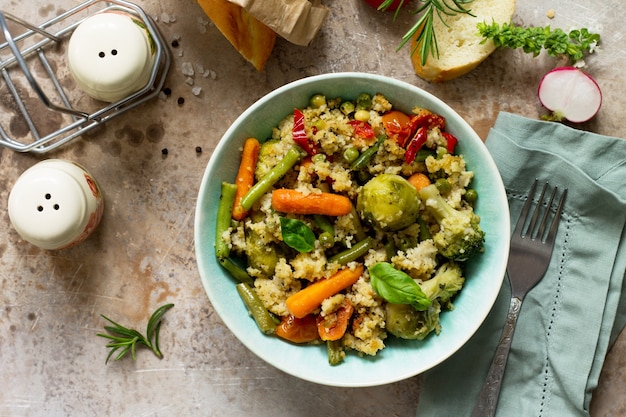 Healthy dietary vegan dish couscous and vegetableson a stone or slate background Top view