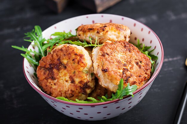 Healthy dinner. Chicken cutlets in a bowl on a dark background.