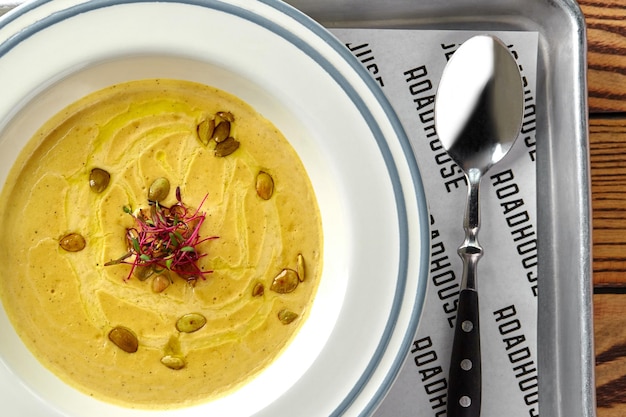 Healthy dinner with pumpkin souppuree served in white bowl