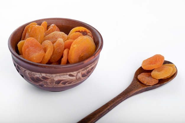 Healthy dried apricot fruits placed on a white background . 