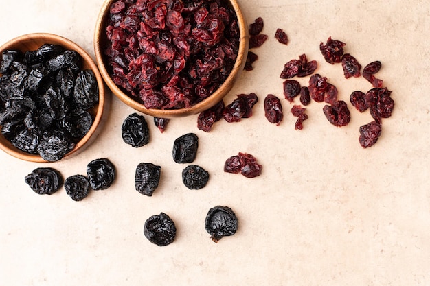 Healthy dried fruit cranberry prunes in a wooden bowl top view flatlay