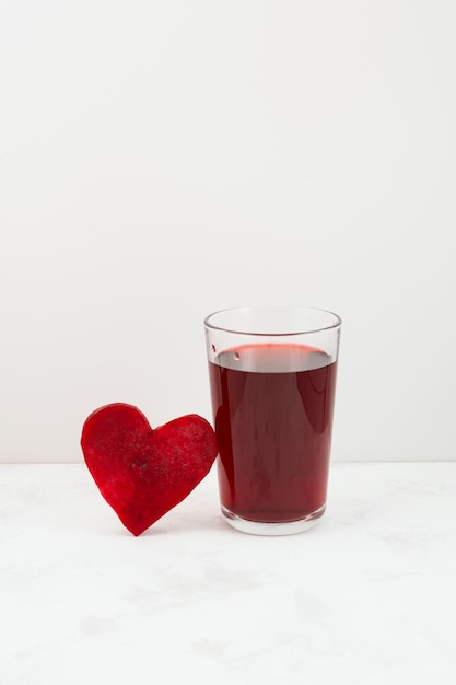 Healthy drink with beetroot juice Glass of red beverage Slice of beet heart shaped Fermented drink