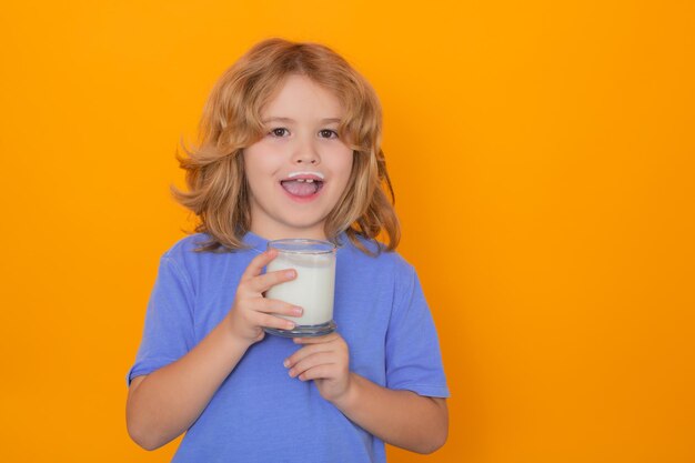 子供のためのカルシウムとタンパク質の健康ドリンク 黄色の背景に牛乳を飲むかわいい子供