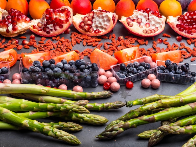 Photo healthy eating background food different fruits asparagus berry on concrete background