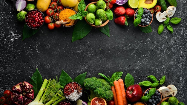 검은 돌 배경 위에 있는 건강한 식생활 개념 야채와 과일 상위 뷰 텍스트를 위한 여유 공간