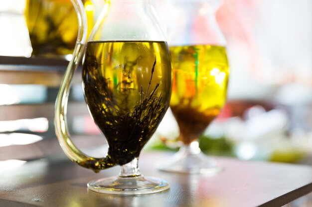 healthy eating, cooking and object concept - close up of glass jug with extra vergin olive oil on table at cafe or restaurant