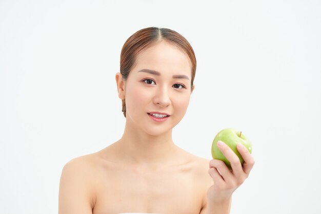 Healthy eating, diet and people concept - smiling young woman with green apple at home