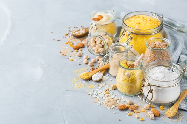 Healthy eating, dieting, balanced food concept. Assortment of gluten free flour, almond, corn, rice on a kitchen table. Copy space background