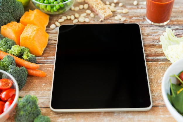 healthy eating, dieting, slimming and weigh loss concept - close up of black blank tablet pc screen and vegetables