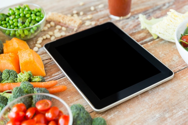 healthy eating, dieting, slimming and weigh loss concept - close up of black blank tablet pc screen and vegetables