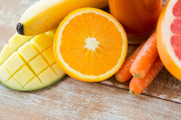 healthy eating, food and diet concept - close up of fresh fruits and juice glass on table