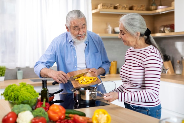 Здоровое питание для пожилых людей портрет пожилых супругов, готовящих вместе на кухне