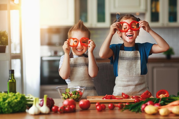 Photo healthy eating happy children prepares and eats vegetable salad in kitchen
