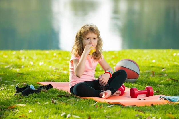 Healthy eating and healthy lifestyle in children boy teenager after sports sitting on sport mat drin...