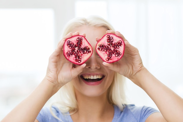 Mangiare sano, cibo biologico, dieta a base di frutta, fumetto e concetto di persone - donna felice che si diverte e si copre gli occhi con il melograno