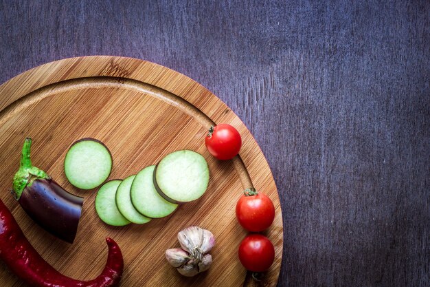 Фото Здоровое питание вегетарианское питание сырые баклажаны, приготовленные для жарки на сковороде со специями в оливковом ...