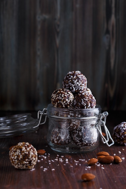 Healthy energy granola bites with nuts, dates, honey and sesame in a glass jar