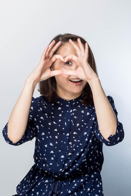 Healthy Eyes And Vision. Portrait Of Beautiful Happy Woman Holding Heart Shaped Hands Near Eyes. Closeup Of Smiling Girl With Healthy Skin Showing Love Sign.