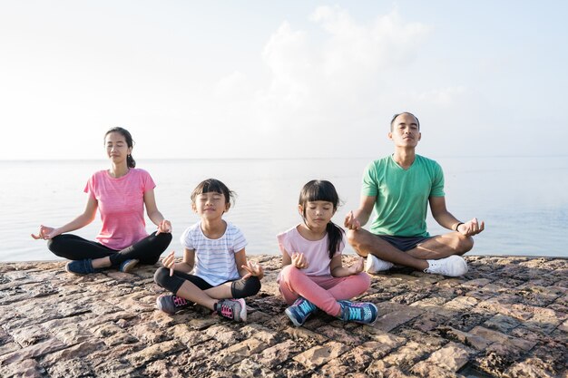 Healthy family meditate together outdoor