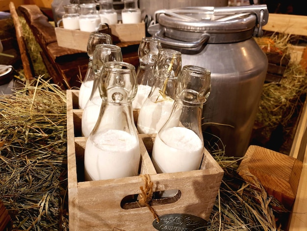 Healthy farm products aluminum cans and glass bottles with fresh natural milk on the hay in the hayl...