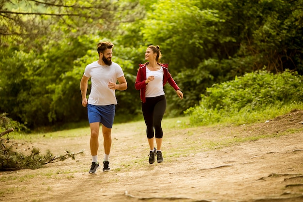 Healthy fit and sportive couple running in nature