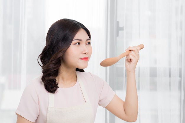 Healthy food. Asian woman cooking in the kitchen with wooden spoon