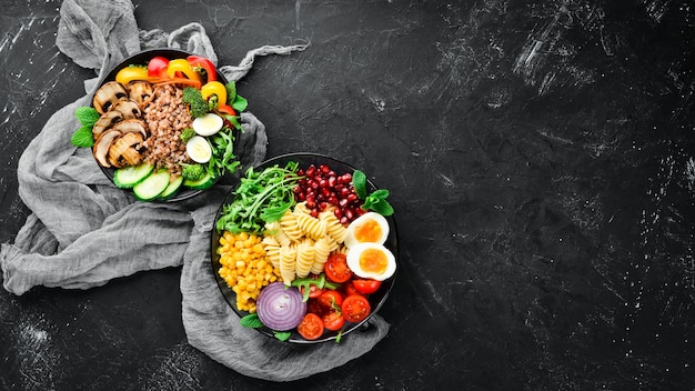 Cibo sano assortimento di buddha bowl su sfondo nero vista dall'alto spazio libero per il testo