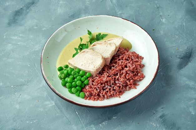 Healthy food - baked chicken fillet with wild rice, peas and curry sauce