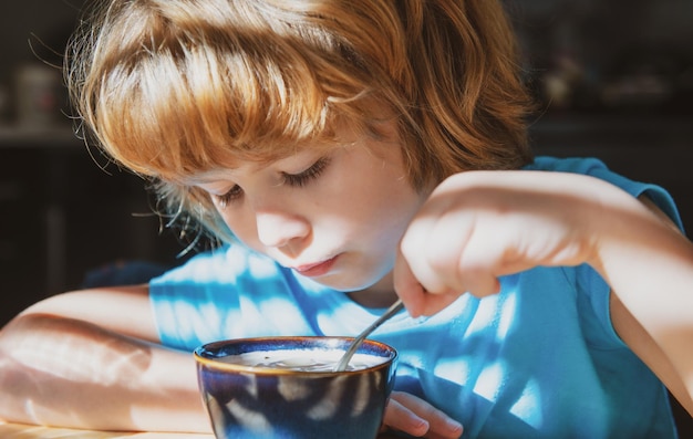 Cibo sano per bambini concetto di nutrizione per bambini il ragazzo mangia in cucina cibo biologico per la casa