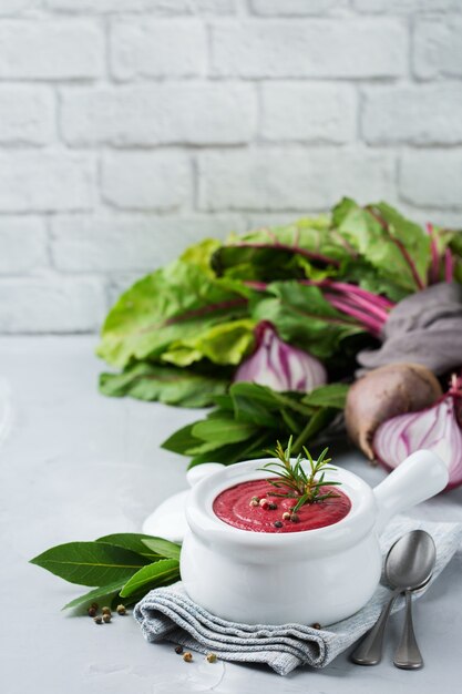 Healthy food, clean eating concept. Seasonal fall autumn vegetables creamy beetroot soup with ingredients on a kitchen table